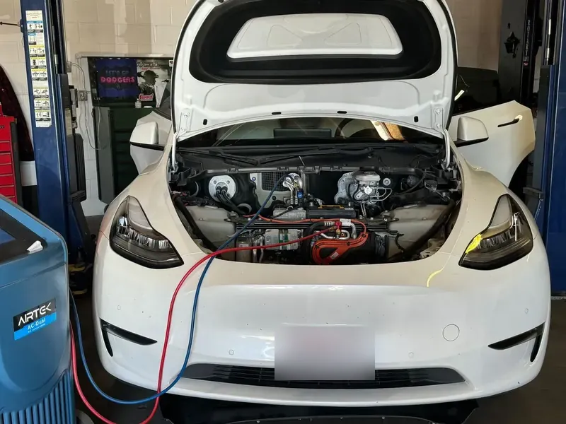 White Tesla Model Y on the A/C machine at Electric City SoCal