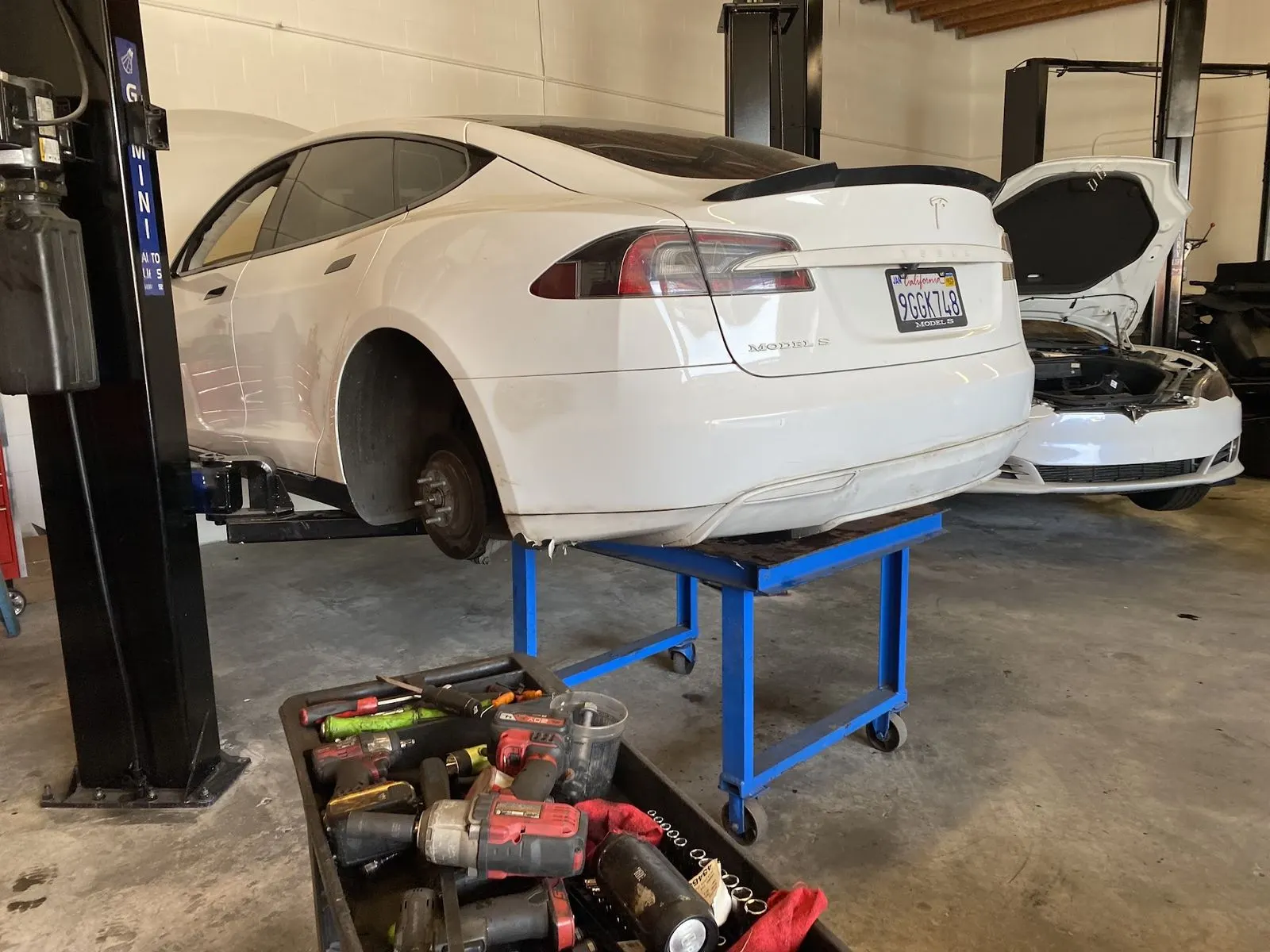 Tesla Model S on the lift at Electric City with front wheels removed for suspension work